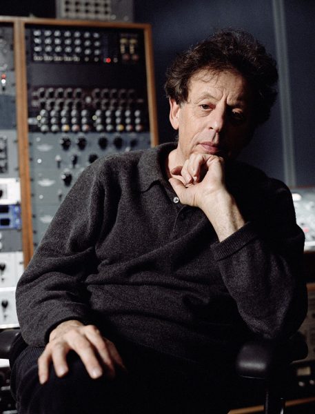 Philip Glass sits at a sound board.