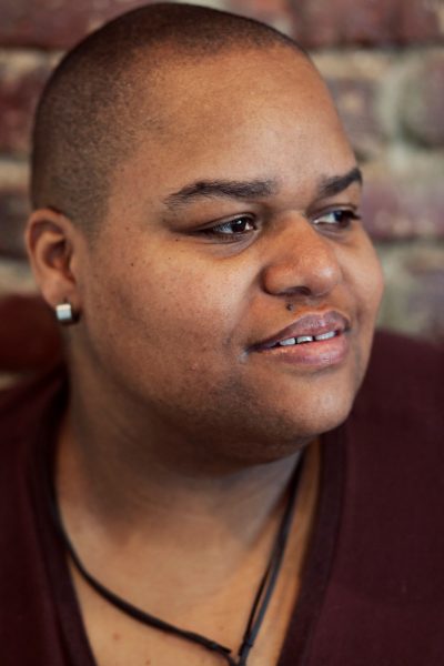 Artist-in-residence Toshi Reagon poses for a headshot in front of a brick wall