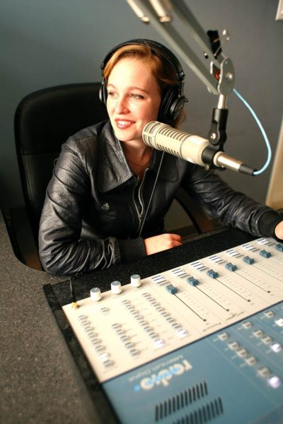 Artist Tift Merritt sits at a sound board in a recording studio.