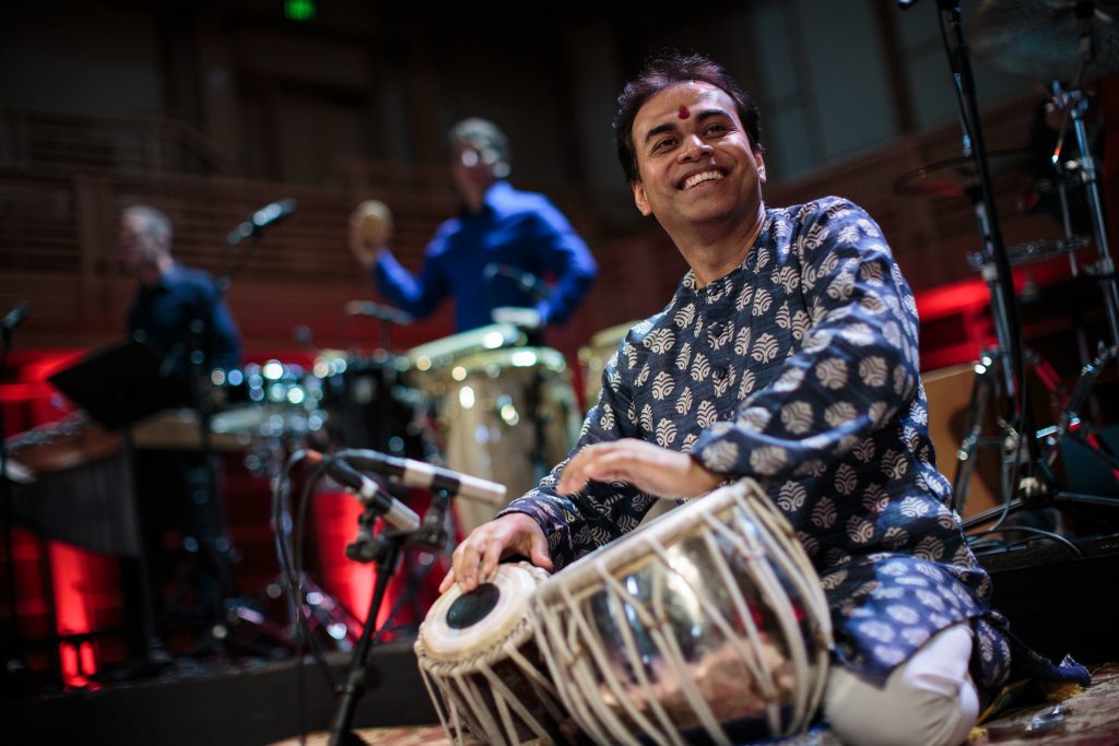Sandeep Das plays the tabla, a short, squat drum, on stage at a concert.