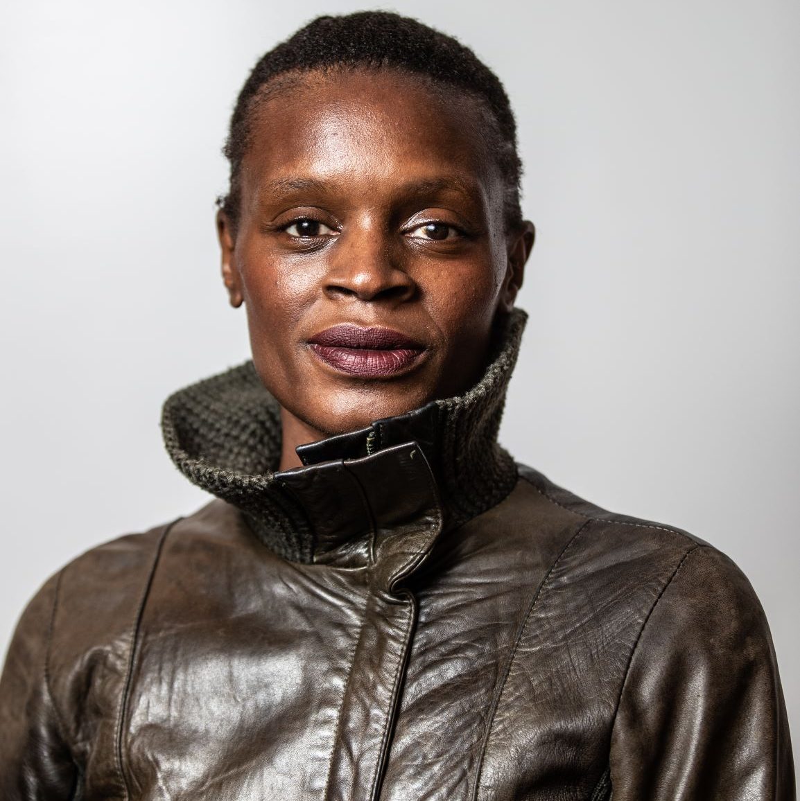 Artist in residence Okwui Okpokwasili poses for a headshot in a leather jacket.