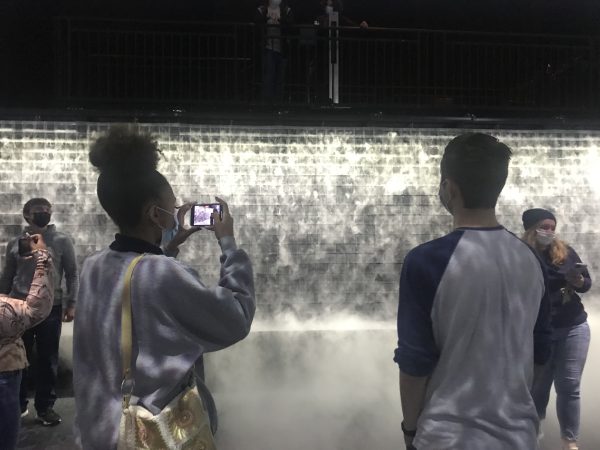 Two students stand in front of Cloud Display, an interactive art piece that uses water vapor to spell out words.