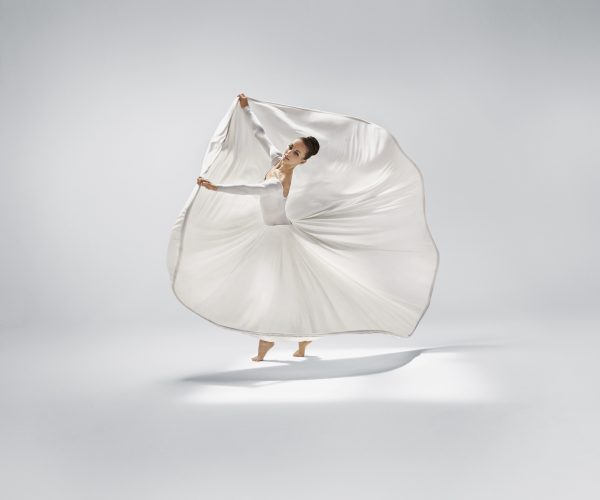 A woman dances in a white, swirling dress.